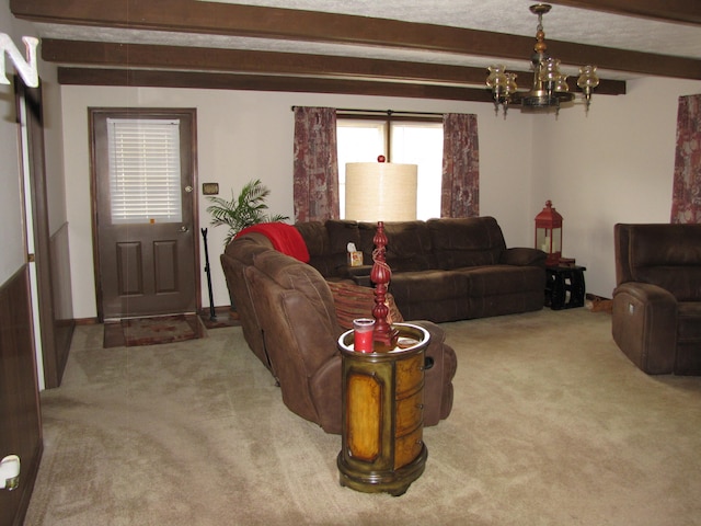 living room featuring carpet flooring, beamed ceiling, and a notable chandelier