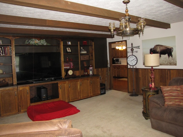 carpeted living room featuring a notable chandelier, wooden walls, a textured ceiling, and beamed ceiling