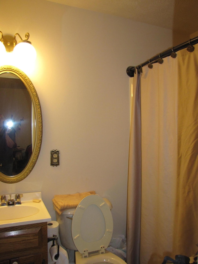 bathroom with walk in shower, vanity, and toilet