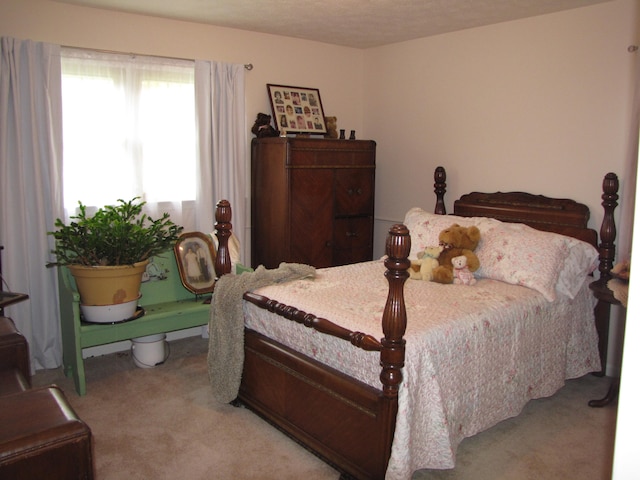 bedroom featuring a textured ceiling and light carpet