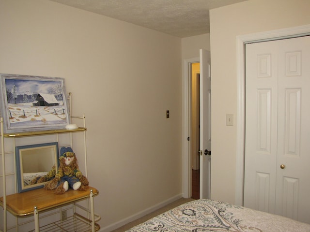 bedroom with a textured ceiling and a closet