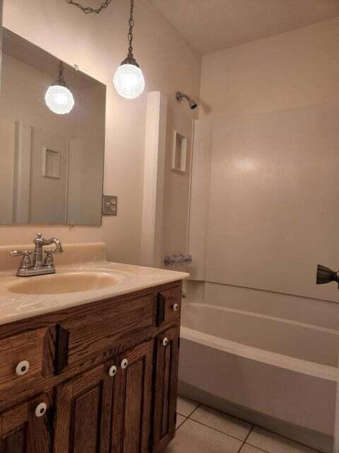 bathroom featuring shower / bathing tub combination, vanity, and tile patterned flooring