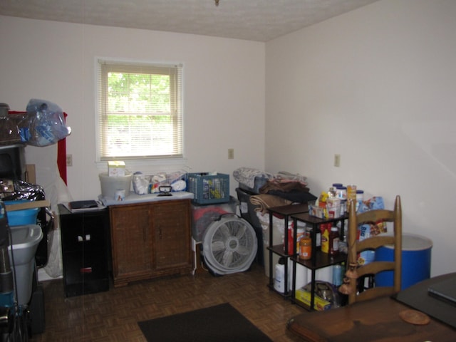 misc room featuring a textured ceiling and dark parquet flooring