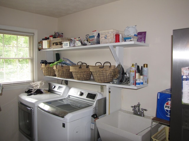 laundry room with separate washer and dryer, a textured ceiling, and sink