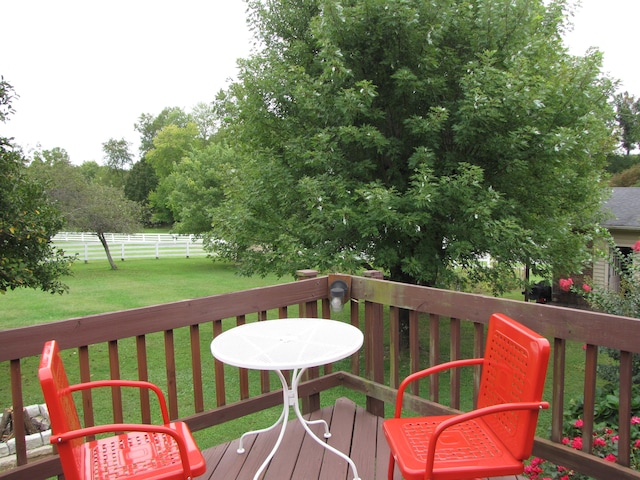 wooden terrace featuring a lawn