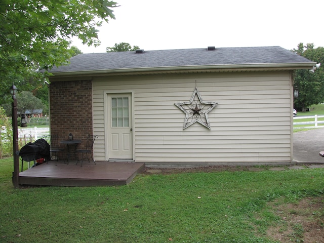 rear view of house featuring a wooden deck and a yard