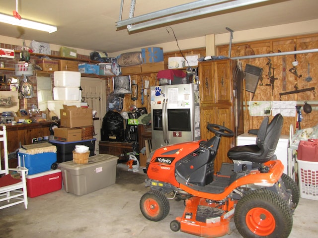 garage featuring stainless steel fridge and a workshop area