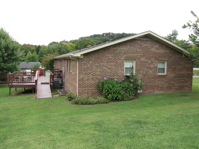 view of property exterior with a wooden deck, central air condition unit, and a lawn