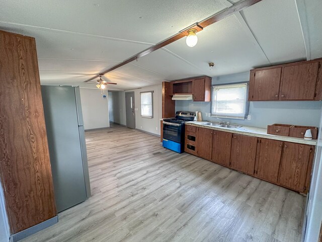 kitchen featuring appliances with stainless steel finishes, light wood-type flooring, sink, and ceiling fan