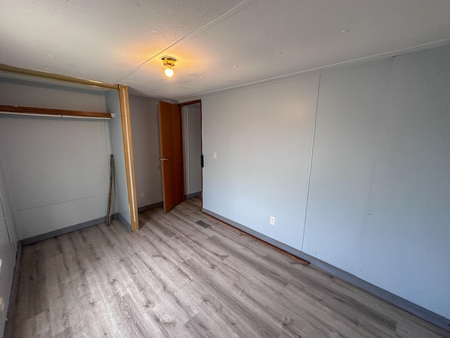 unfurnished bedroom featuring a textured ceiling and light hardwood / wood-style floors