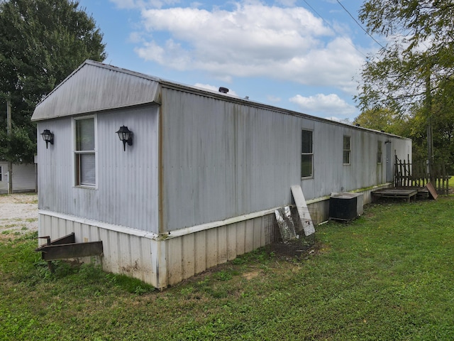 view of property exterior with central AC unit and a lawn