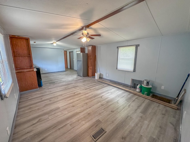 unfurnished living room with ceiling fan, lofted ceiling, and light hardwood / wood-style floors