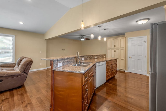 kitchen with stainless steel fridge, vaulted ceiling, white dishwasher, a kitchen island with sink, and sink