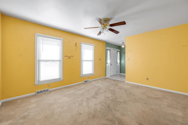 carpeted spare room featuring ceiling fan