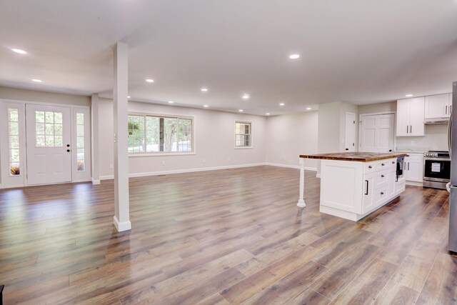 kitchen with white cabinets, plenty of natural light, light hardwood / wood-style floors, and electric range