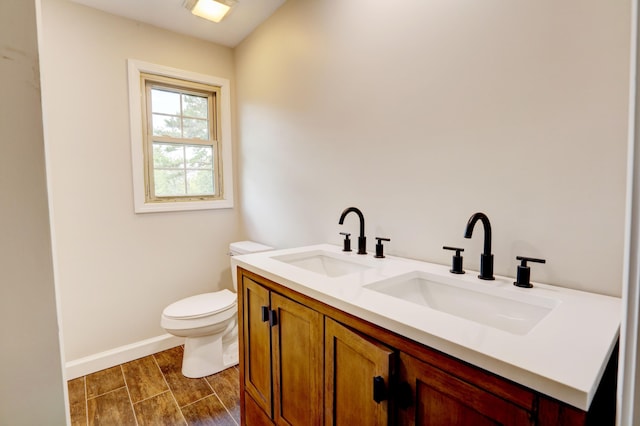 bathroom featuring wood-type flooring, vanity, and toilet