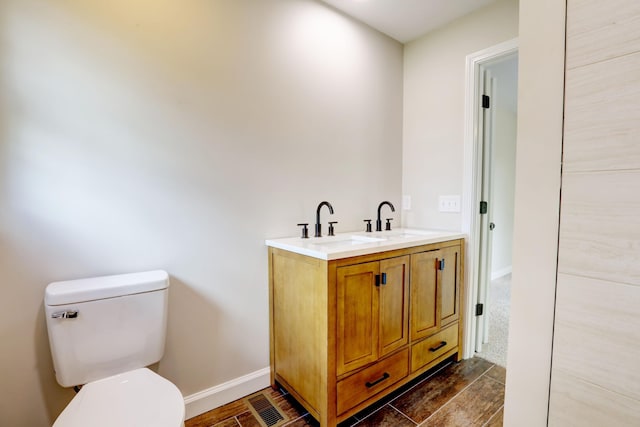 bathroom featuring wood-type flooring, vanity, and toilet