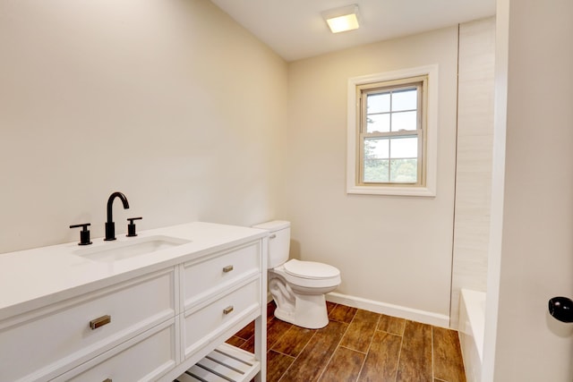 bathroom featuring wood-type flooring, vanity, and toilet