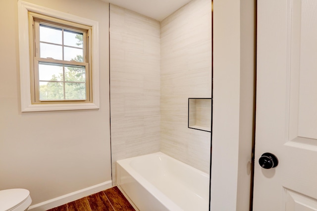 bathroom with hardwood / wood-style flooring, toilet, and shower / bathtub combination