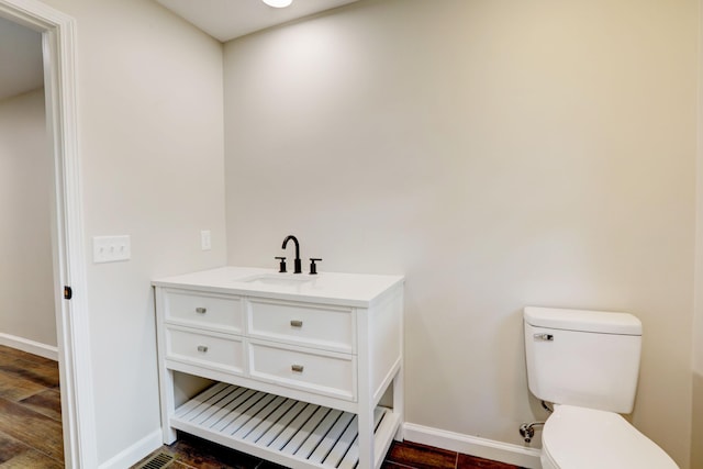 bathroom featuring hardwood / wood-style floors, vanity, and toilet