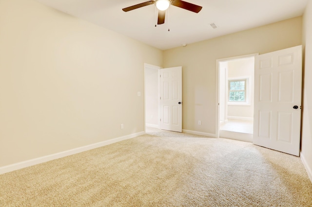 carpeted spare room featuring ceiling fan