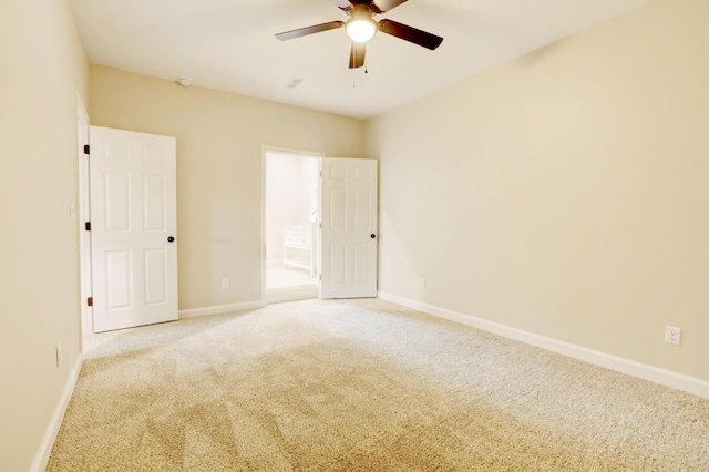 carpeted spare room featuring ceiling fan