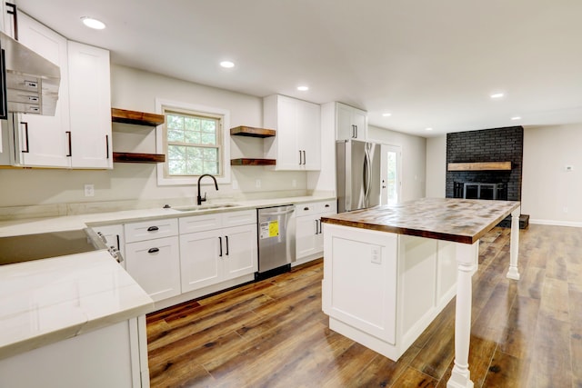 kitchen featuring appliances with stainless steel finishes, white cabinetry, and sink