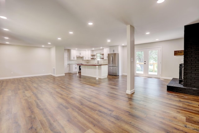 unfurnished living room featuring a fireplace, hardwood / wood-style floors, and sink