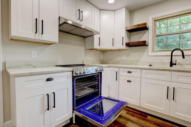 kitchen with white cabinets, light stone countertops, range with electric cooktop, dark hardwood / wood-style floors, and sink