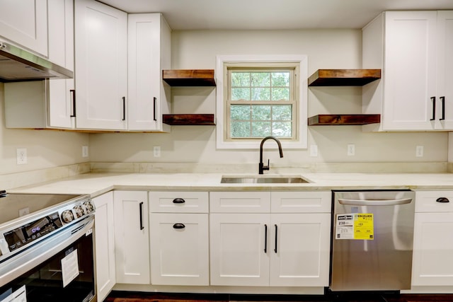 kitchen with appliances with stainless steel finishes, white cabinetry, sink, and extractor fan