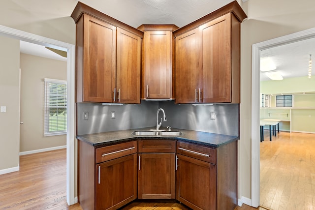 706 Hunter Dr, Lancaster, KY 40444 - kitchen featuring a sink, baseboards, brown cabinets, and light wood finished floors