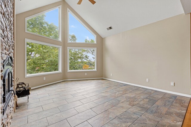 unfurnished living room featuring high vaulted ceiling, ceiling fan, and a wealth of natural light