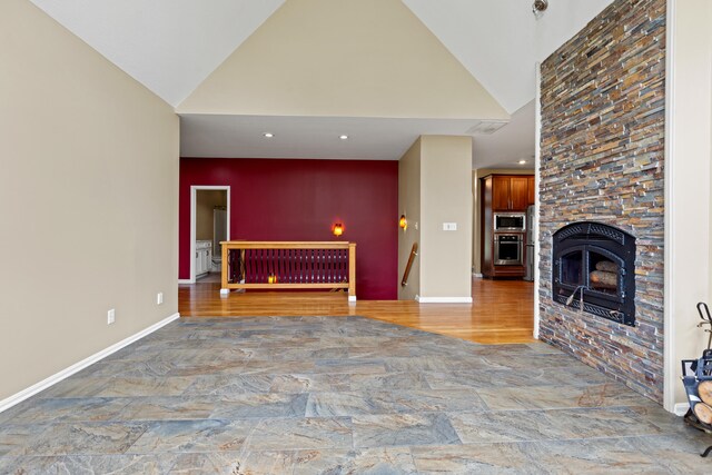 unfurnished living room with a fireplace, high vaulted ceiling, and hardwood / wood-style flooring