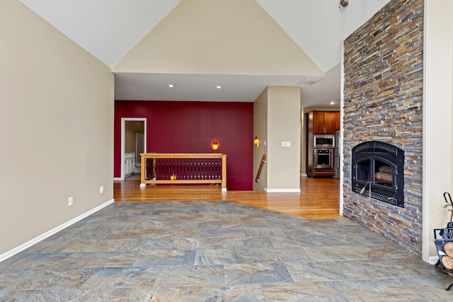 706 Hunter Dr, Lancaster, KY 40444 - unfurnished living room with a fireplace, high vaulted ceiling, an accent wall, and baseboards