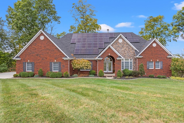 front facade featuring a front lawn and solar panels