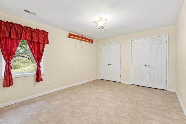 706 Hunter Dr, Lancaster, KY 40444 - unfurnished bedroom featuring visible vents, baseboards, and two closets