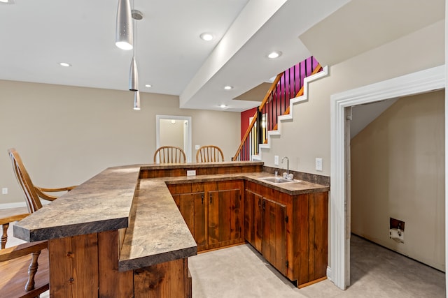 kitchen featuring pendant lighting, sink, kitchen peninsula, light carpet, and a breakfast bar area