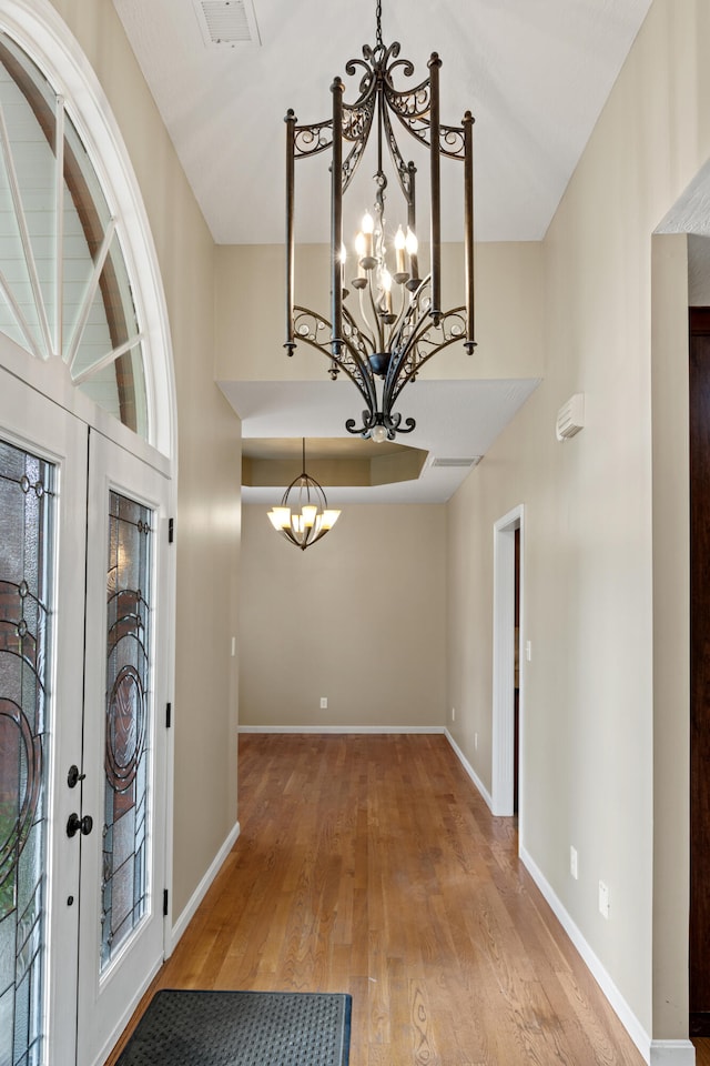 foyer entrance featuring light hardwood / wood-style flooring, a chandelier, and a healthy amount of sunlight