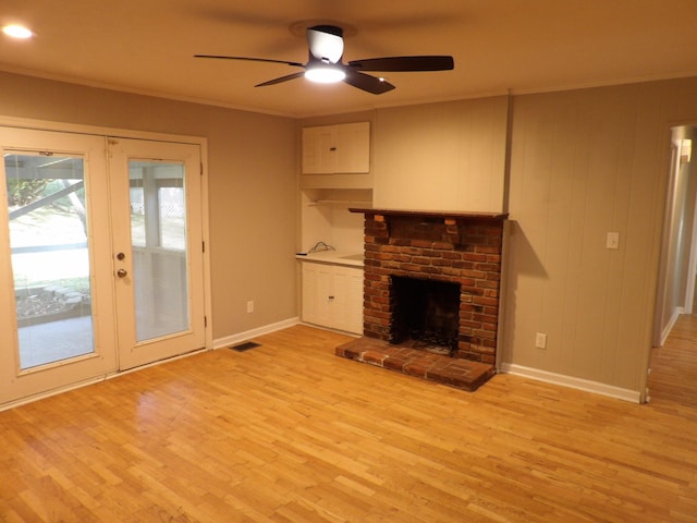 unfurnished living room featuring ornamental molding, a brick fireplace, ceiling fan, and light wood-type flooring