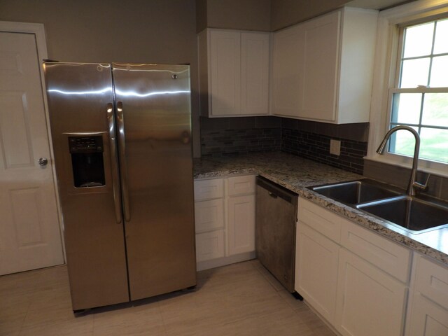 kitchen with decorative backsplash, stainless steel appliances, white cabinets, and sink