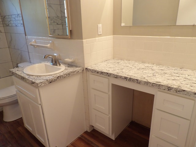 bathroom with tile walls, wood-type flooring, vanity, and toilet