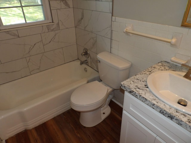 full bathroom with tile walls, vanity, shower / bathing tub combination, hardwood / wood-style flooring, and toilet