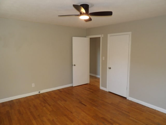 empty room with ceiling fan and hardwood / wood-style flooring