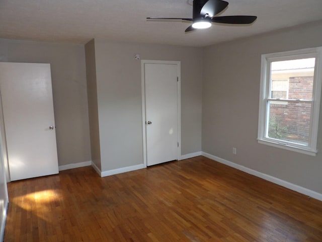 unfurnished room with ceiling fan and dark hardwood / wood-style floors