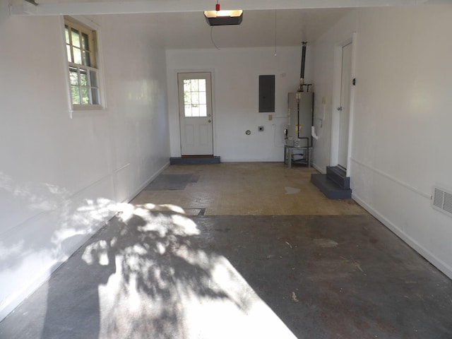 garage featuring a garage door opener, gas water heater, and electric panel