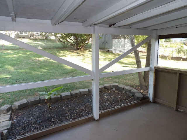 unfurnished sunroom featuring beam ceiling