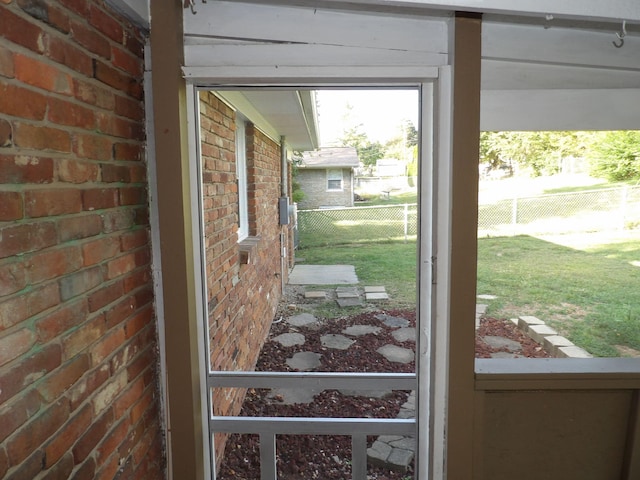 doorway featuring brick wall