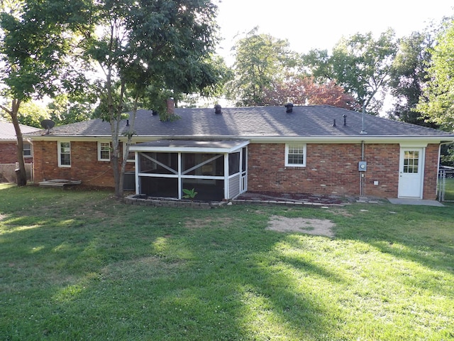 rear view of property featuring a sunroom and a lawn