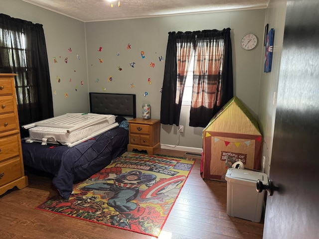 bedroom featuring hardwood / wood-style flooring and a textured ceiling