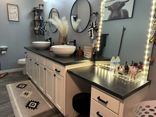 bathroom with hardwood / wood-style flooring, vanity, and toilet